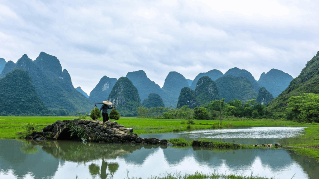 Limestone peaks and tranquil waters of the Li River in Guilin, southern China, with traditional raft boats.