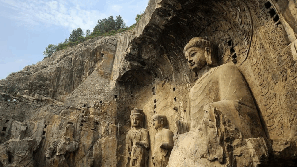 Intricate Buddha statues carved into limestone cliffs at the Longmen Grottoes in Luoyang, Henan Province.