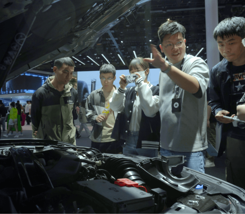 Group learning about modern Chinese car hardware at an auto show