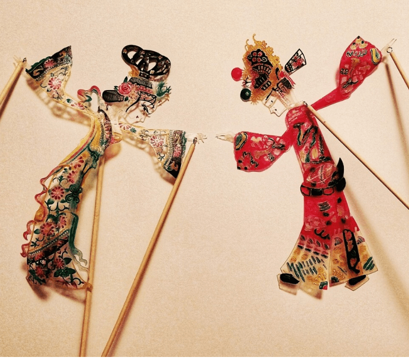 Shadow puppetry performance with two traditional Chinese puppets