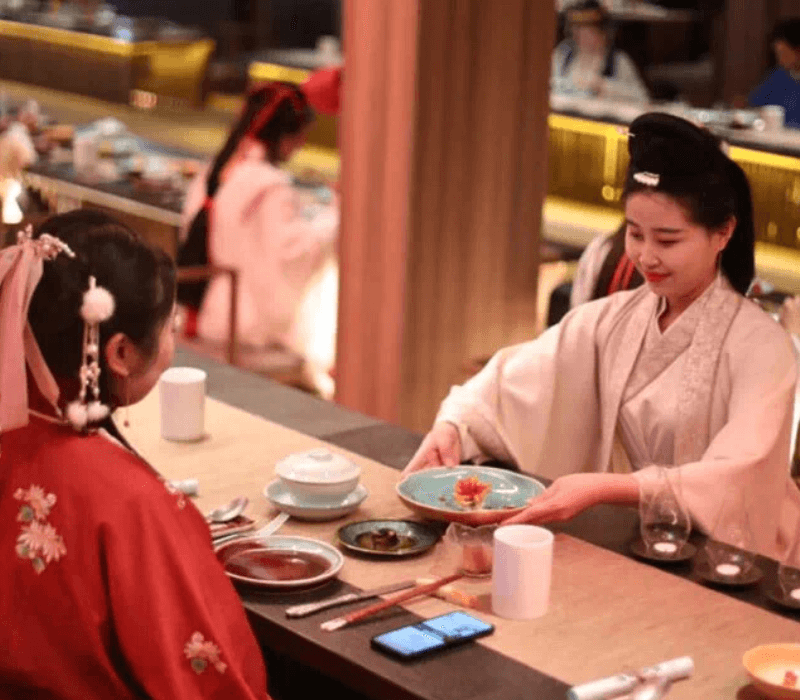 Two girls participating in a traditional Chinese banquet experience