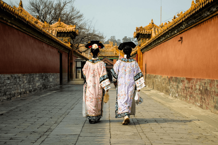Travelers in hanfu walking down a traditional alley during cultural tour