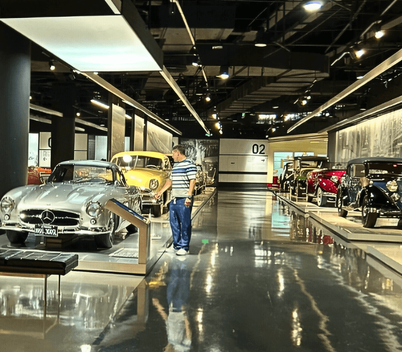 Visitor exploring multiple vintage car exhibits at Shanghai Auto Museum