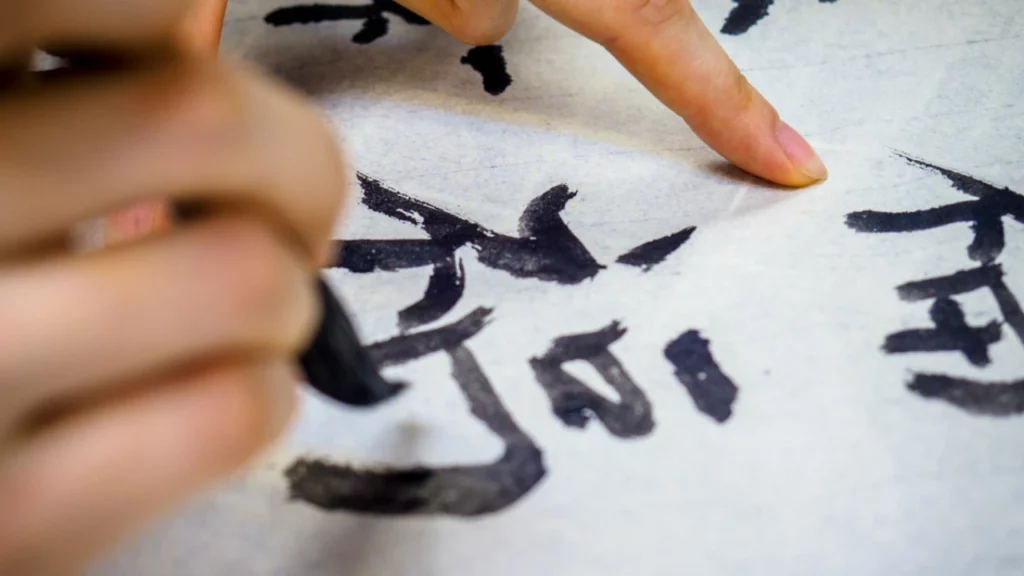 Chinese calligraphy artist writing the character fortune 福 with brush and ink