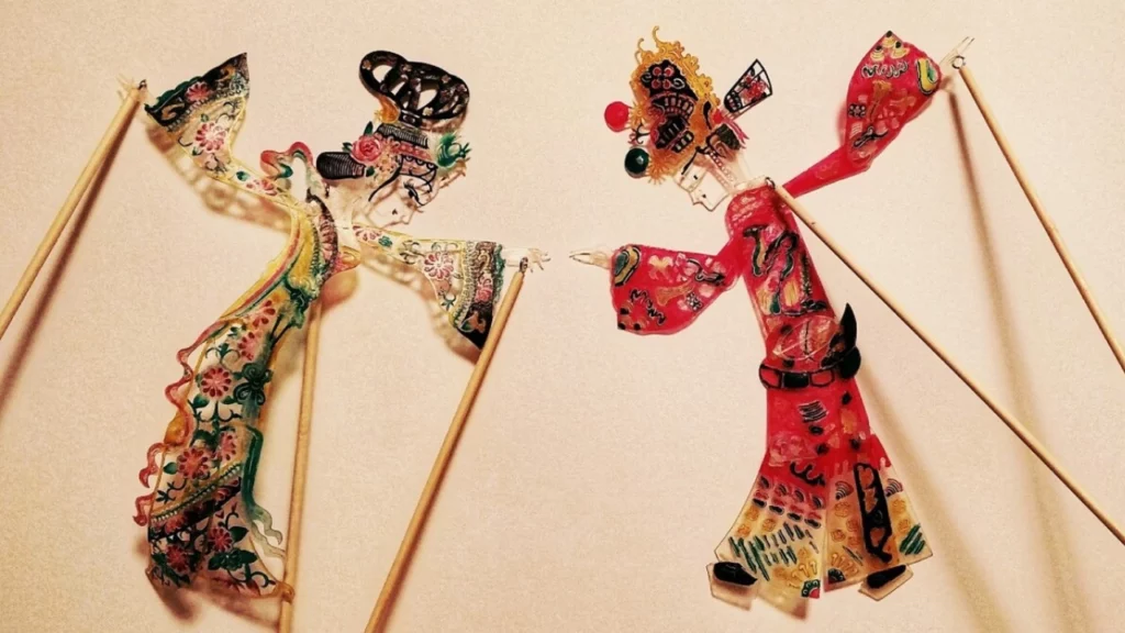 Chinese shadow puppetry performance with colorful puppets and bamboo sticks
