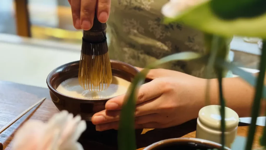 Chinese tea master whisking powdered tea into creamy foam using Song Dynasty tea ceremony method